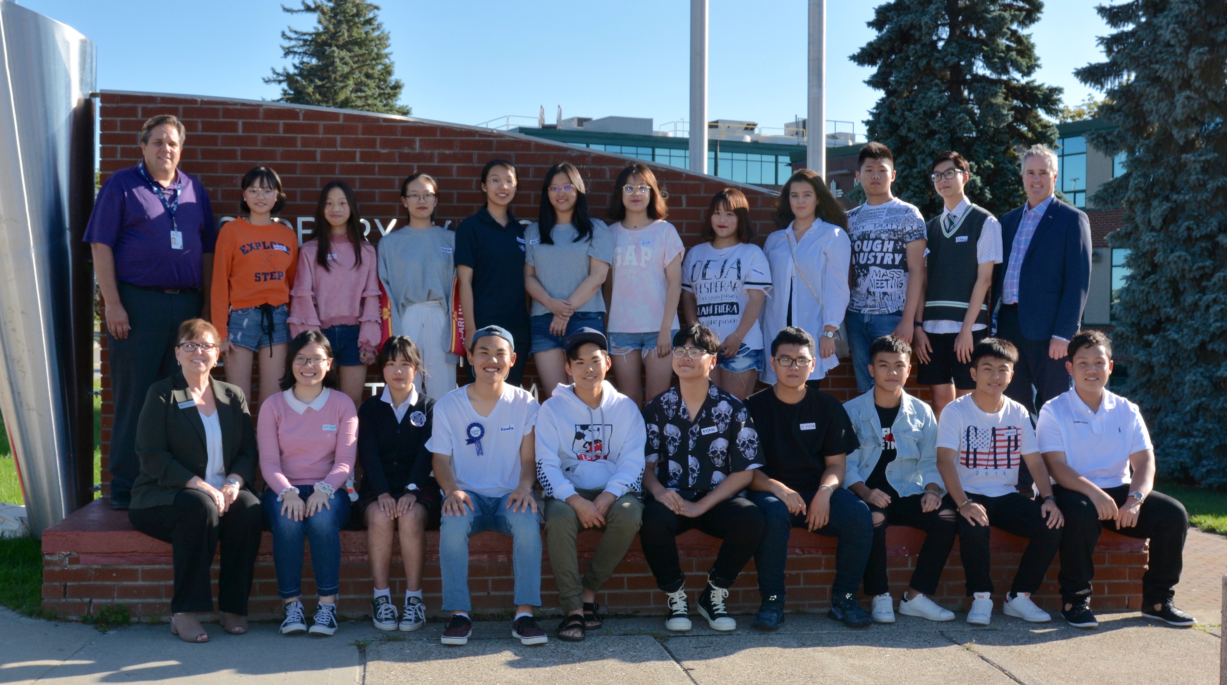 30 students, from the countries of China, Japan, Vietnam and Spain stand with Director of Education Joanne Bénard, Board Chair Michael Bellmore and Superintendent Terry Ppaineau.